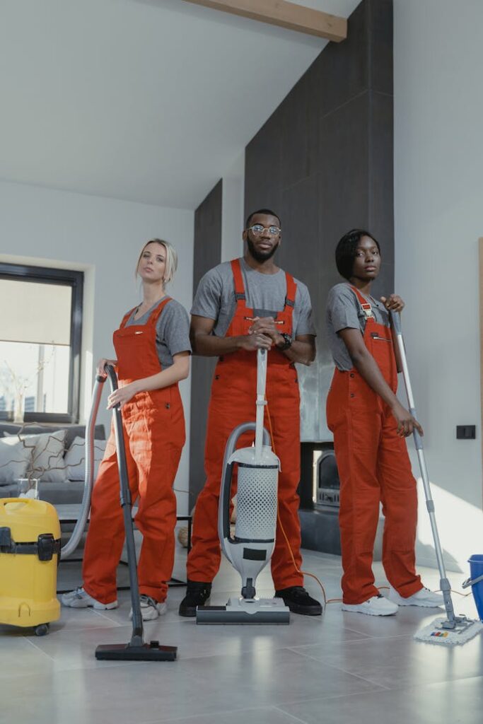 pexels-photo-6195131 Three cleaners in uniform with equipment in a modern home interior, showcasing teamwork and professionalism.